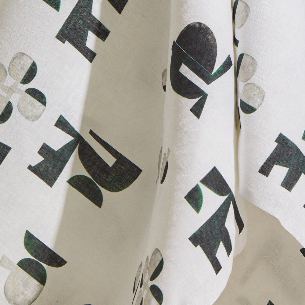 Draped fabric yardage in an abstract geometric print in mottled green and cream on a white field.