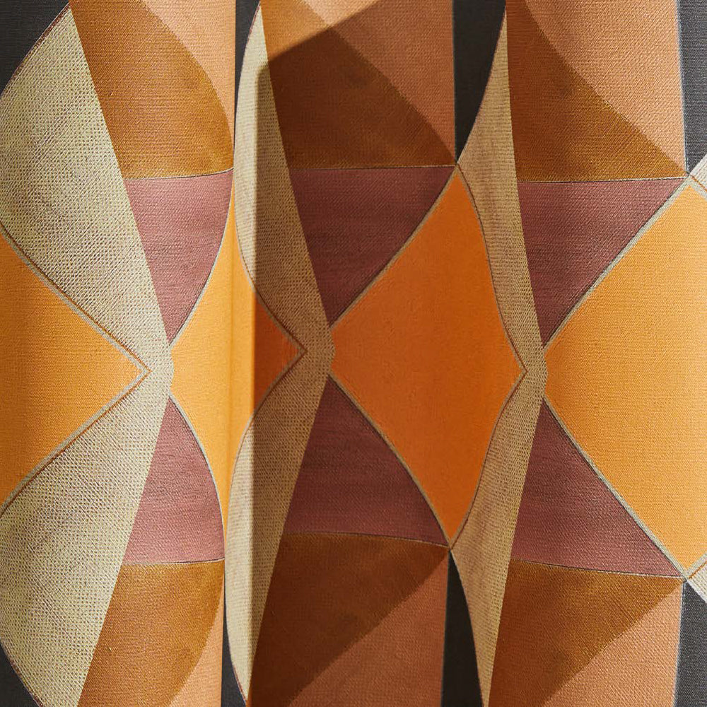 Draped wallpaper yardage in a large-scale triangle print in shades of orange, tan, pink and gray.