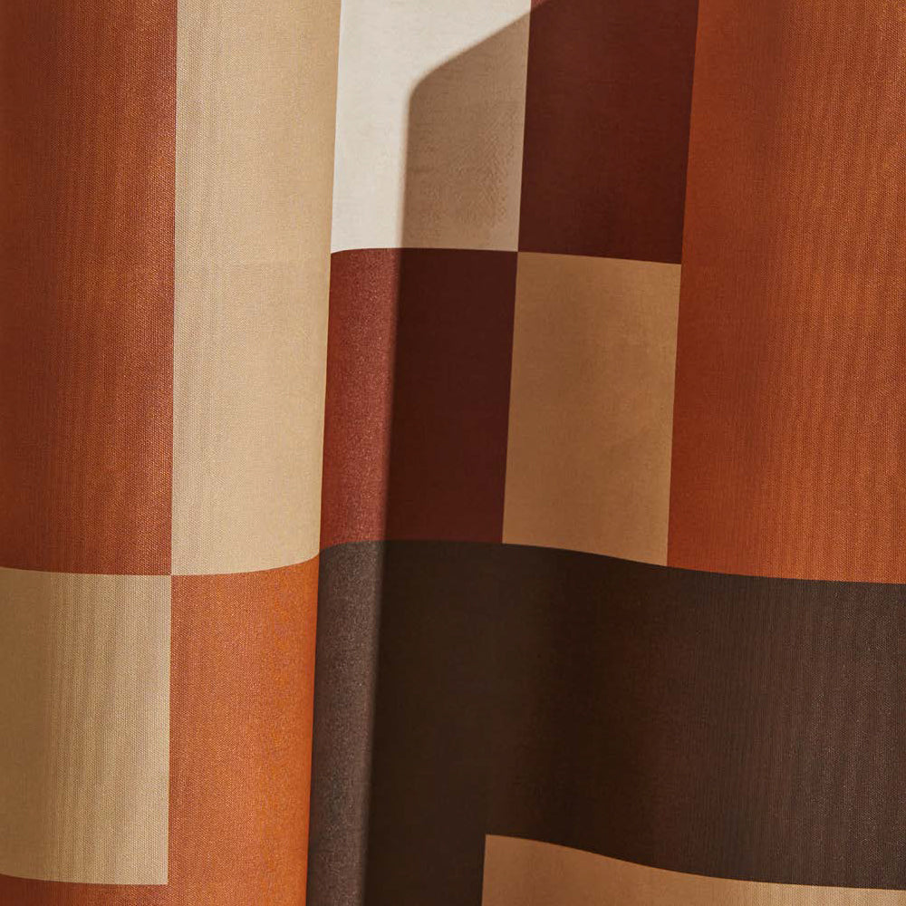 Draped wallpaper yardage in an interlocking square pattern in shades of brown, rust and cream.