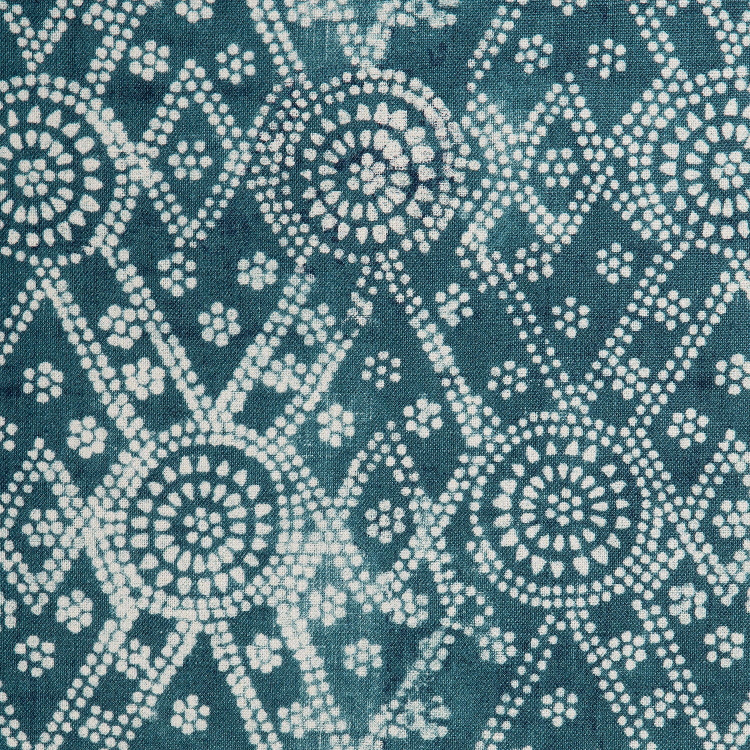 Detail of a linen fabric in a gridded dot pattern in white on a mottled indigo field.