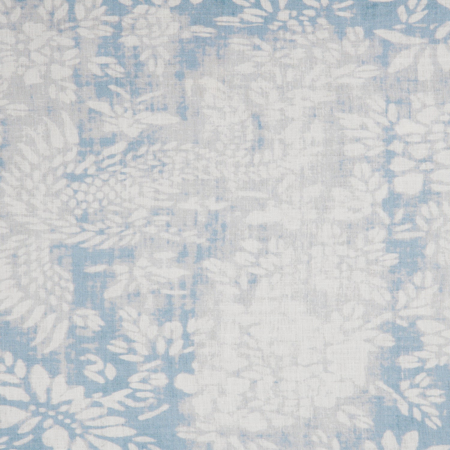 Detail of a linen fabric in a floral and leaf pattern in white on a mottled blue and gray field.