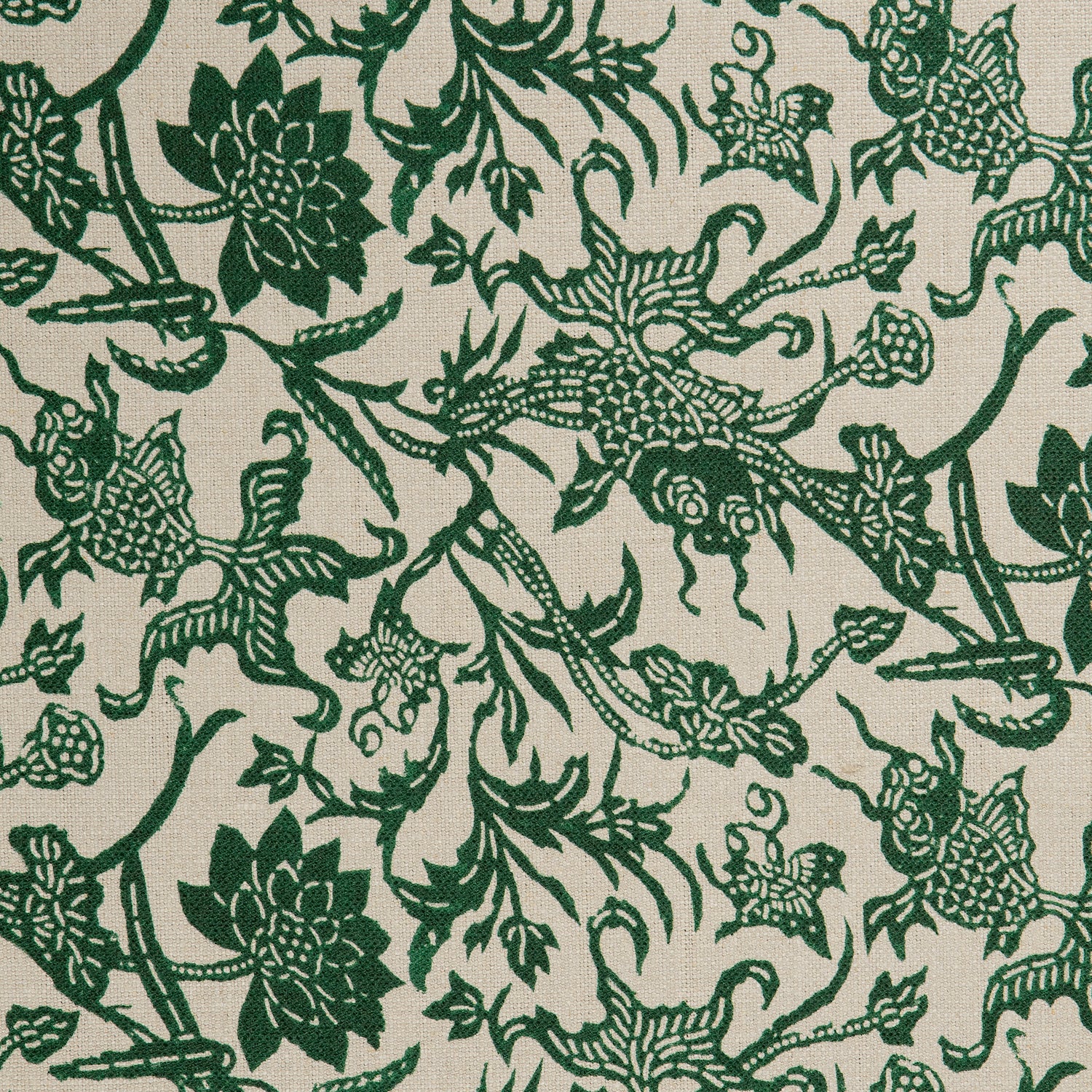 Detail of a linen fabric in a carp and leaf pattern in green on a beige field.
