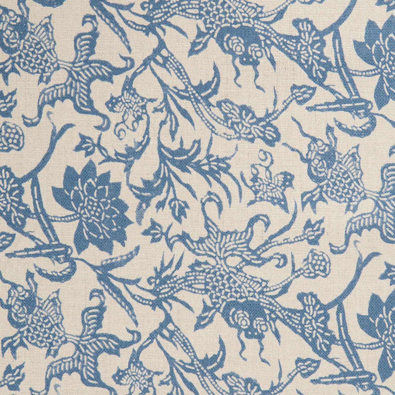 Detail of a linen fabric in a carp and leaf pattern in blue on a beige field.