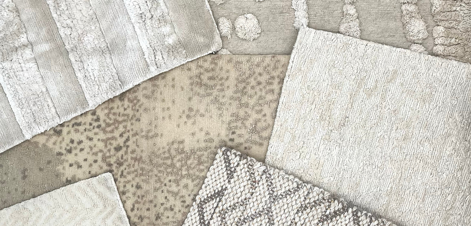 A close up shot of handmade rug samples all in shaes of cream. 