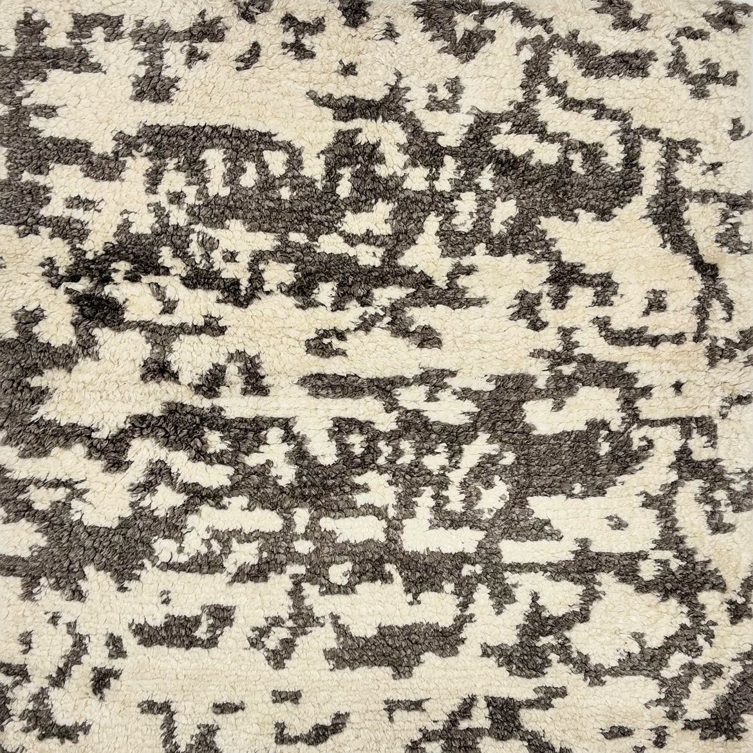 Detail of a silk rug in cream and charcoal in an abstract textural pattern.