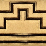 Detail of a handknotted rug with a geometric stripe pattern in brown on a cream field.