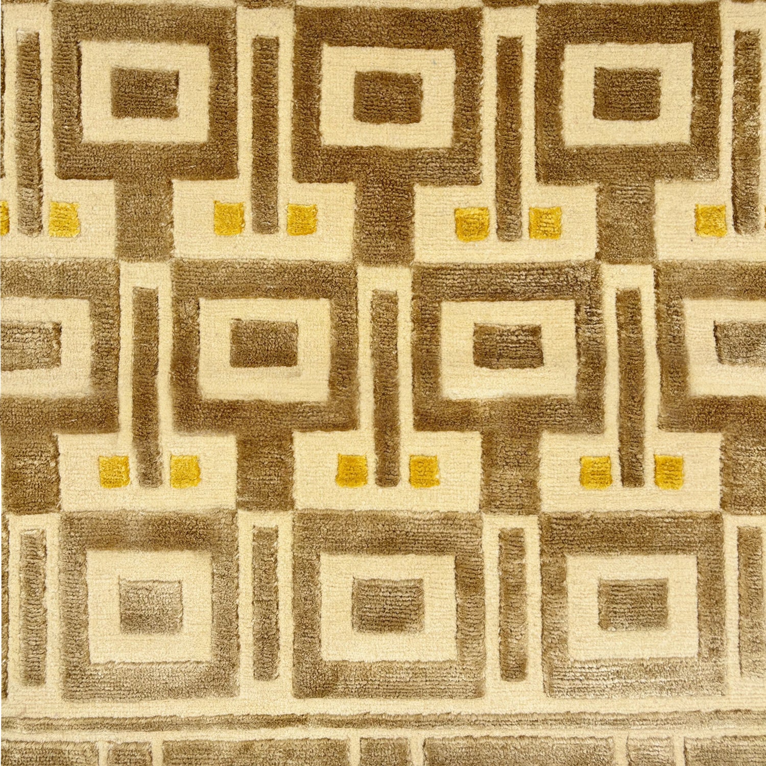 Detail of a geometric patterned rug in cream, brown and yellow.