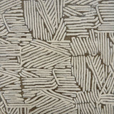 Detail of rug with an abstract woodcut inpsired pattern in grey and cream