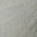 A swatch of blended linen-wool mix fabric in a flecked cream color with blue overtones.