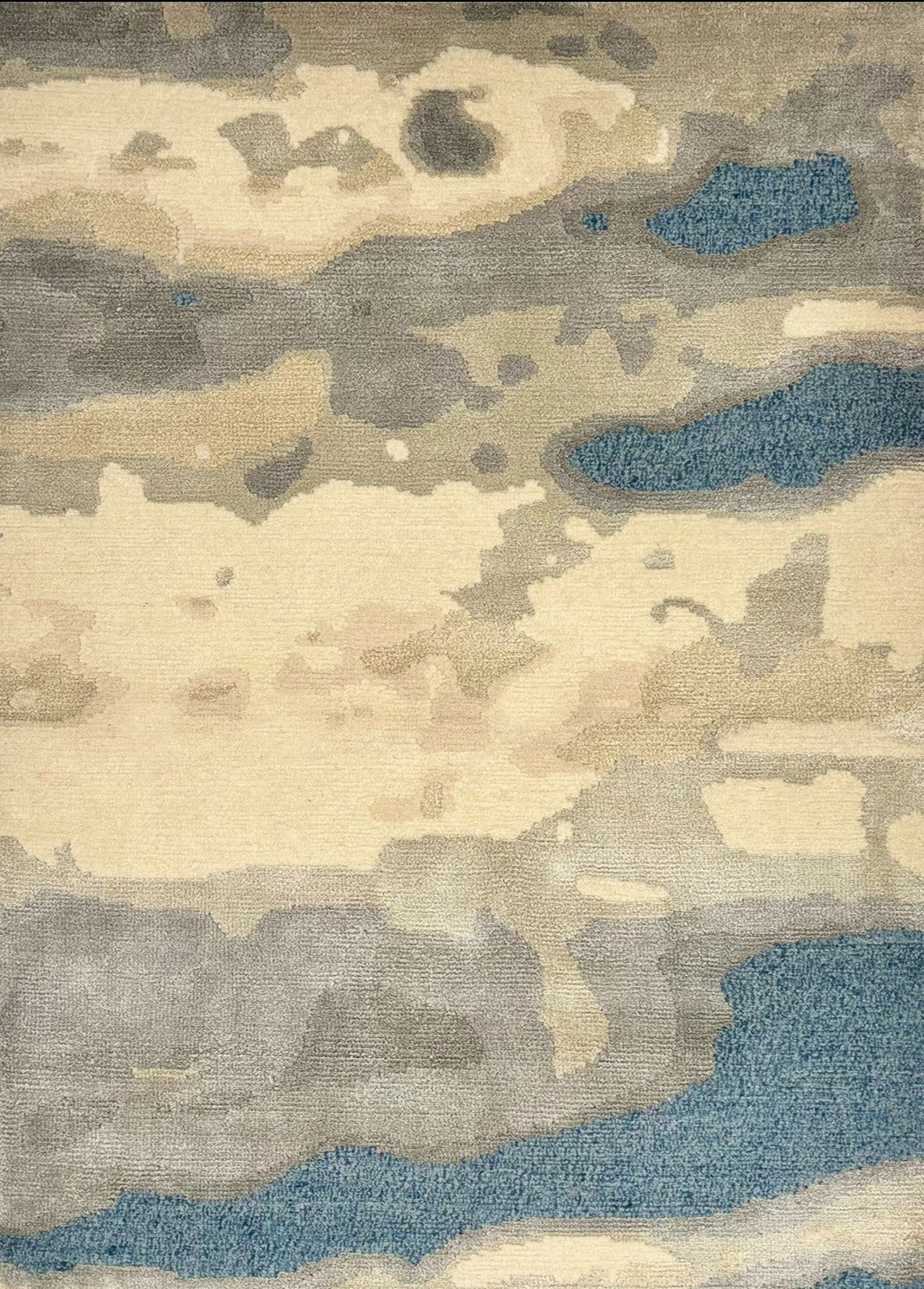 Detail of a woolblend rug in tan, cream and acqua in an abstract textural pattern.