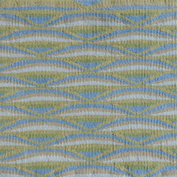 Detail of handwoven rug in a wavy striped pattern in shades of green and blue