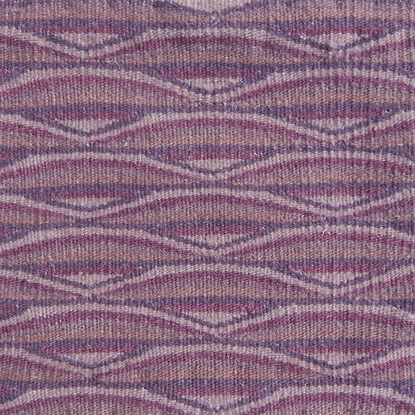 Detail of handwoven rug in a wavy striped pattern in shades of purple