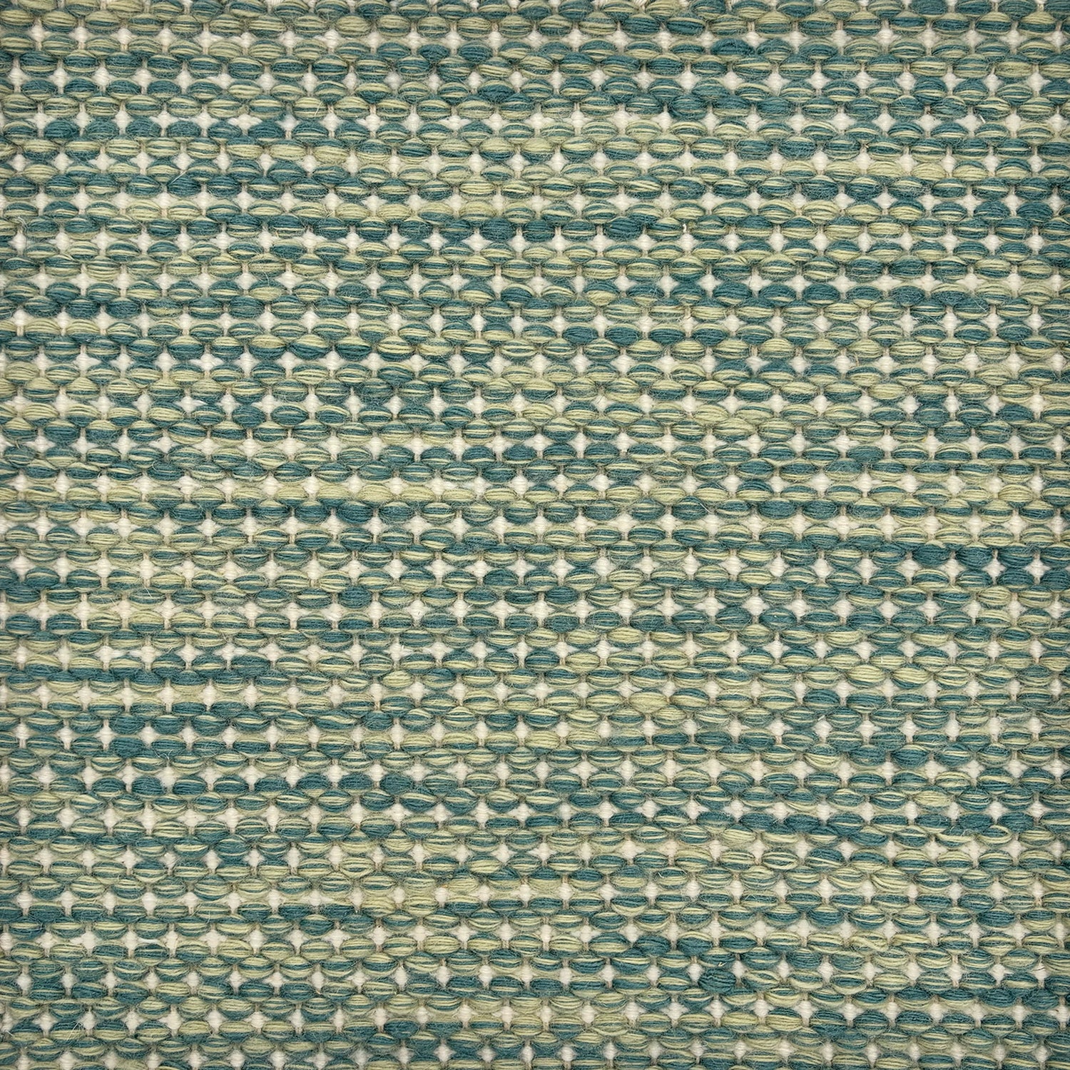 Detail of a handowven rug with a textural strié pattern in shades of green