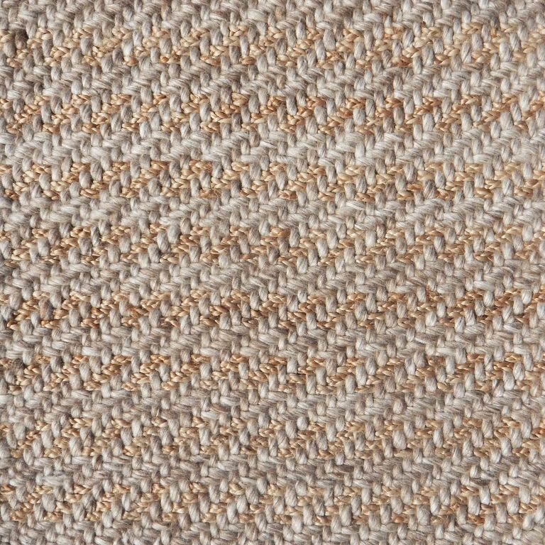 Detail of a textural rug in natural fiber and ecru yarn.