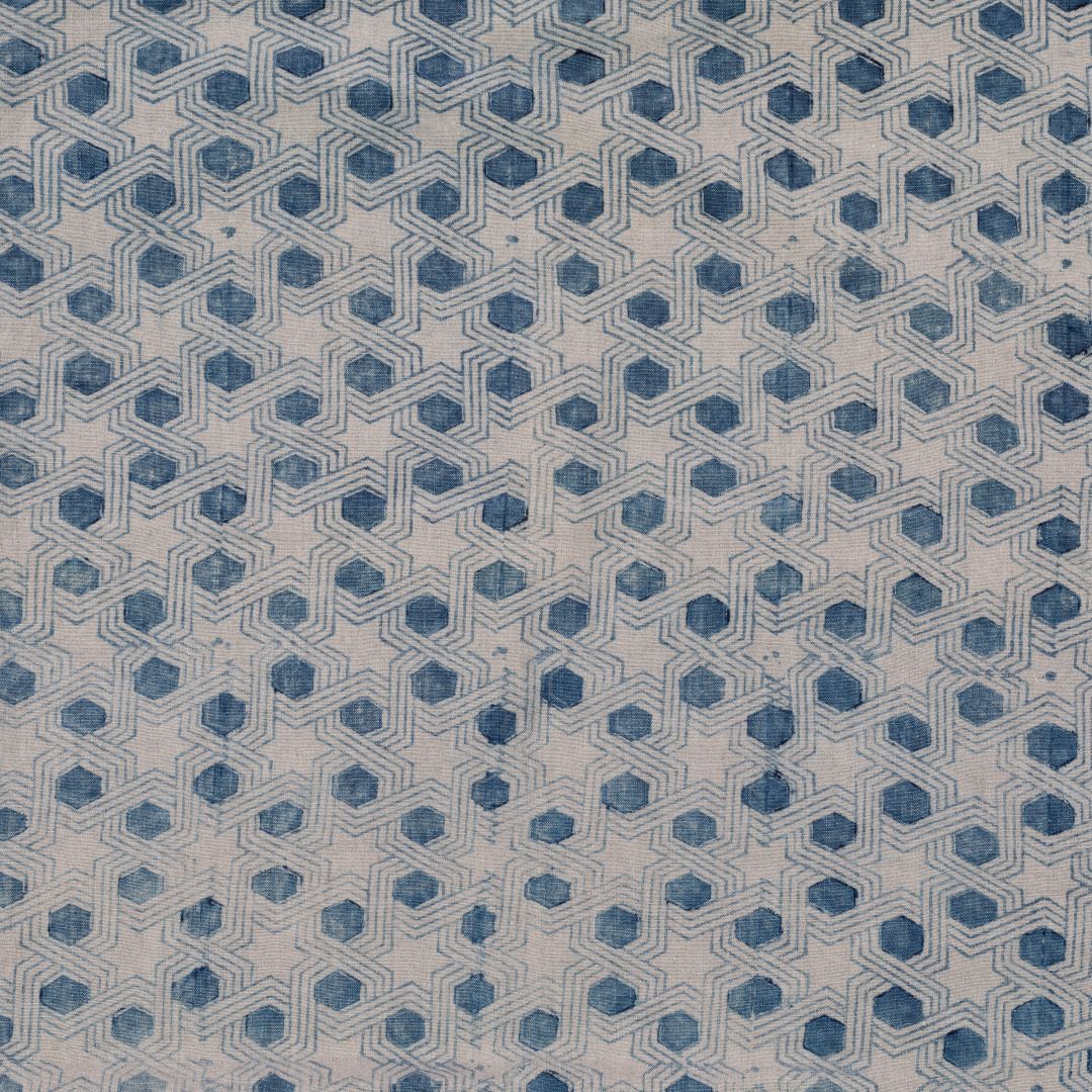 Detail of fabric in a star-shaped lattice print in navy on a cream field.
