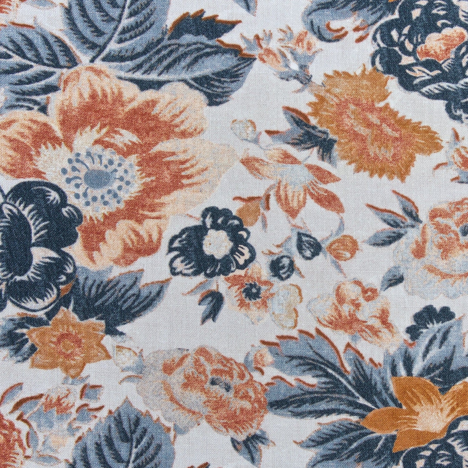 Detail of a linen fabric in a detailed floral pattern in shades of blue and orange on a cream field.