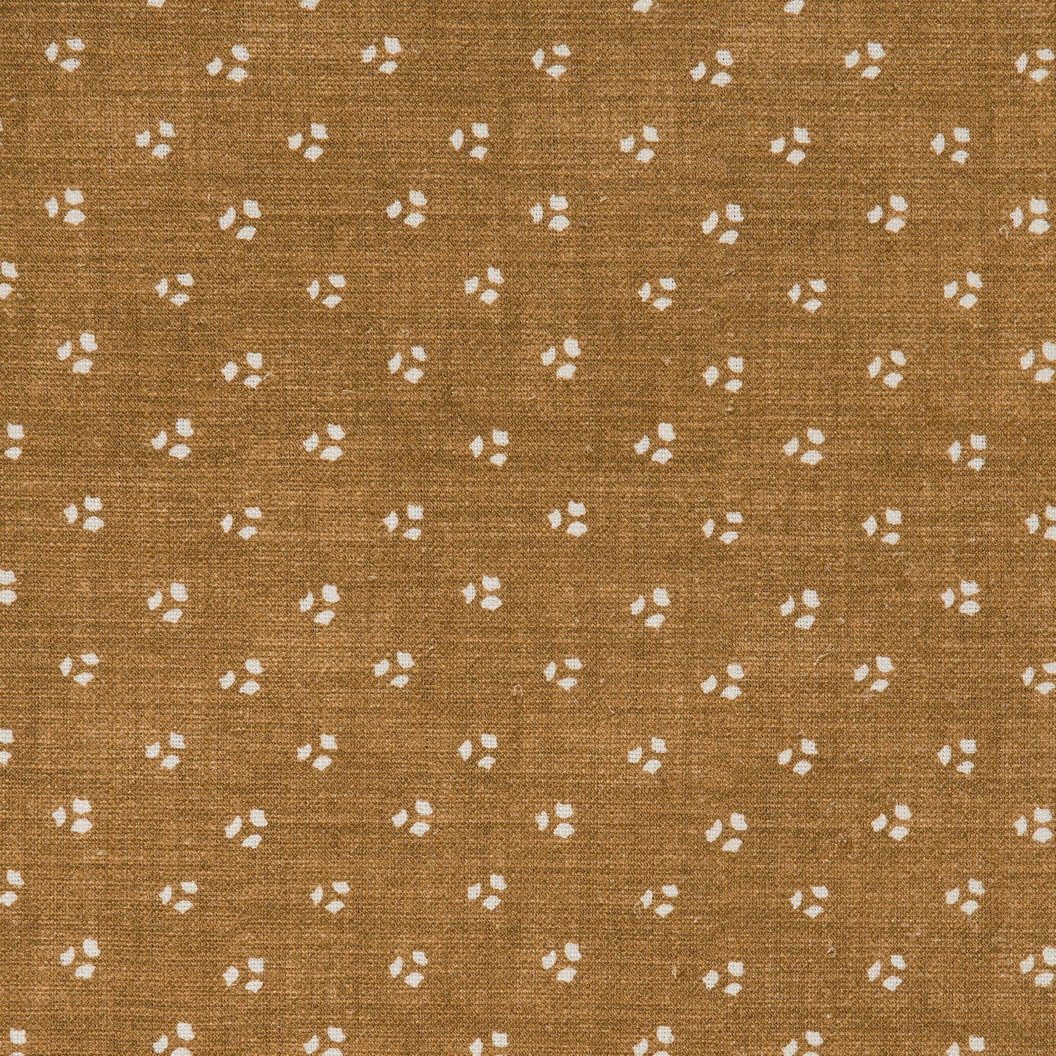 Detail of a linen fabric in a clustered dot pattern in cream on a camel field.