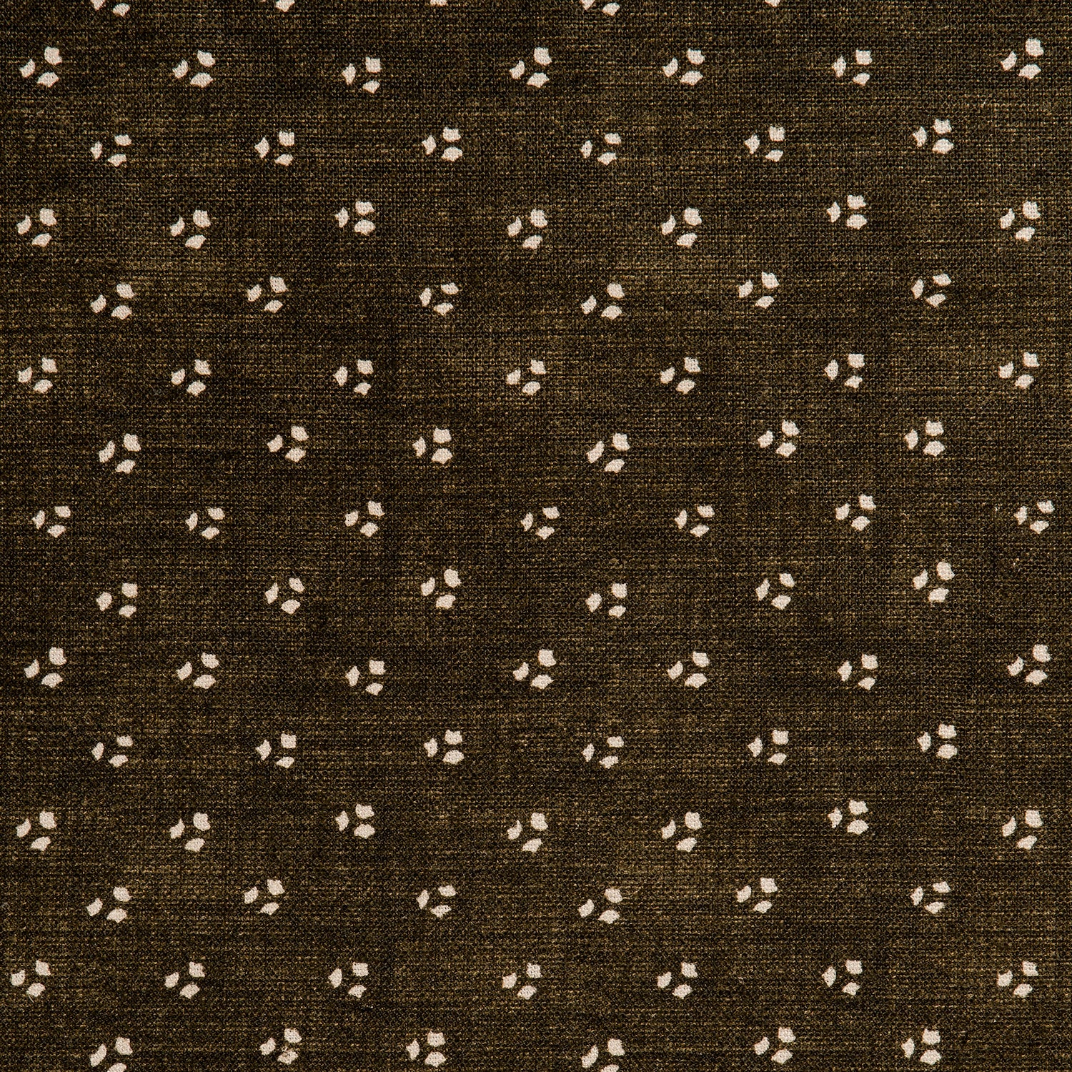 Detail of a linen fabric in a clustered dot pattern in cream on a dark brown field.