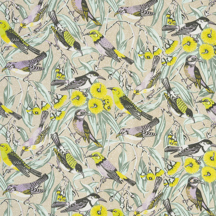 Fabric detail of a dense bird and branch pattern in yellow, sage blue and pale lilac on a tan field.