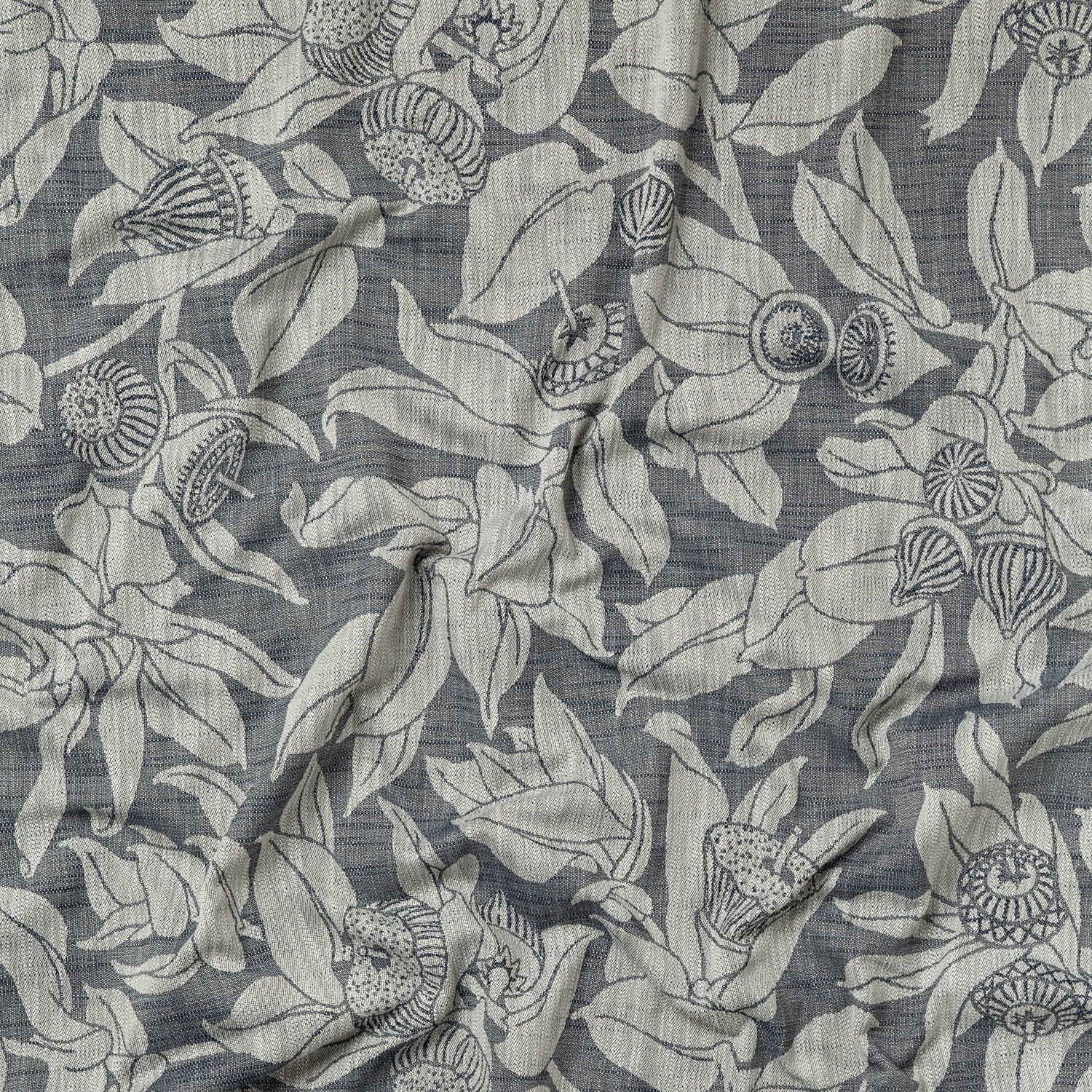 Draped fabric in a leaf and bud print in gray on a dark gray field.