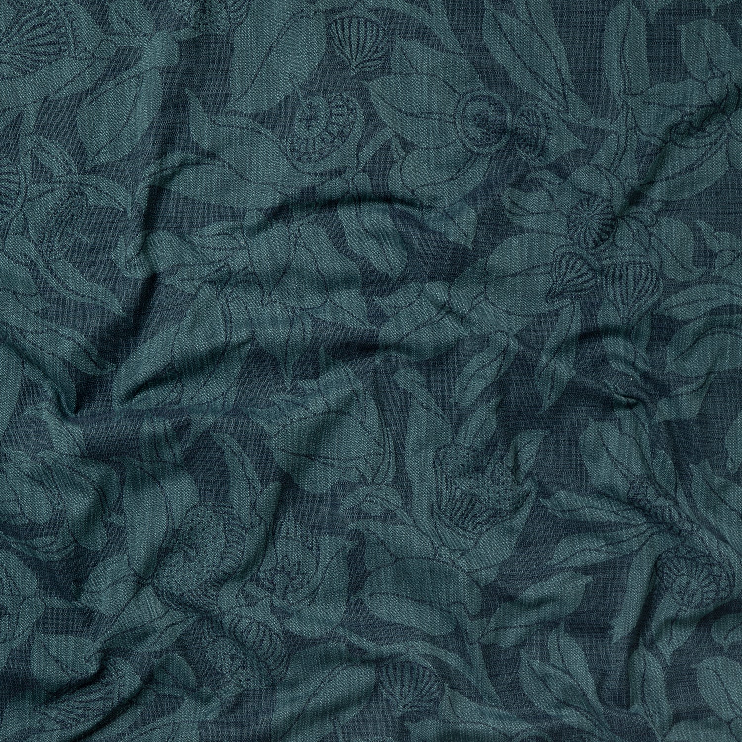Draped fabric in a leaf and bud print in dark blue on a navy field.