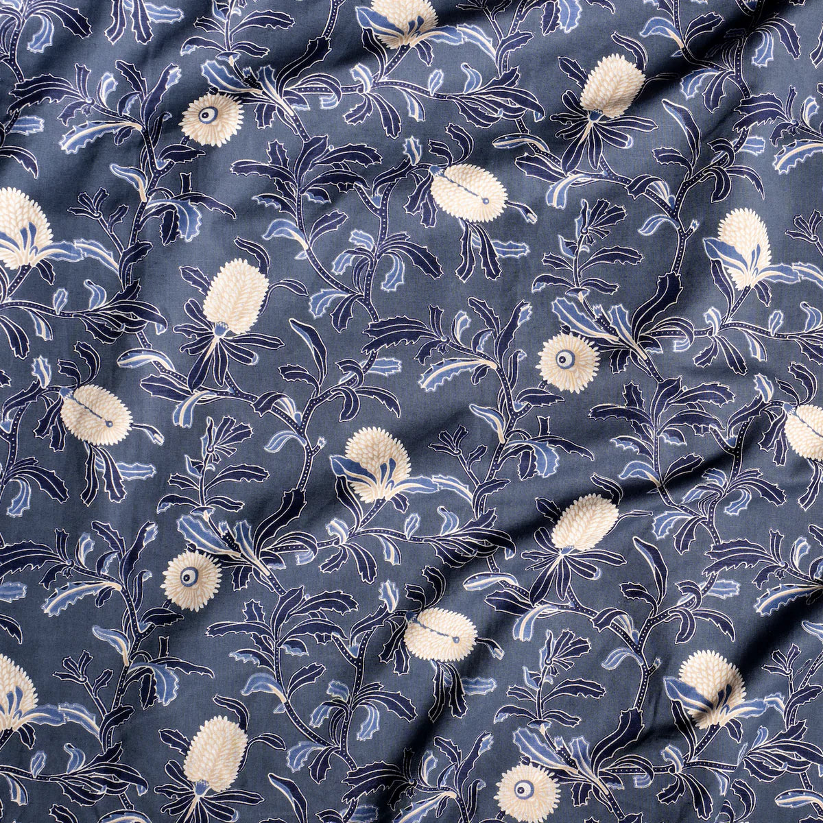 Draped fabric in a floral print in shades of navy and tan on a navy field.