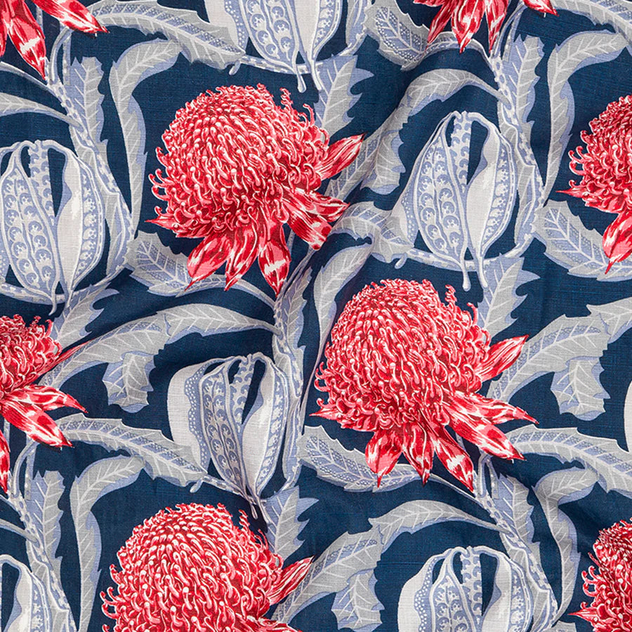 Draped fabric in a large-scale floral print in shades of blue and red on a navy field.