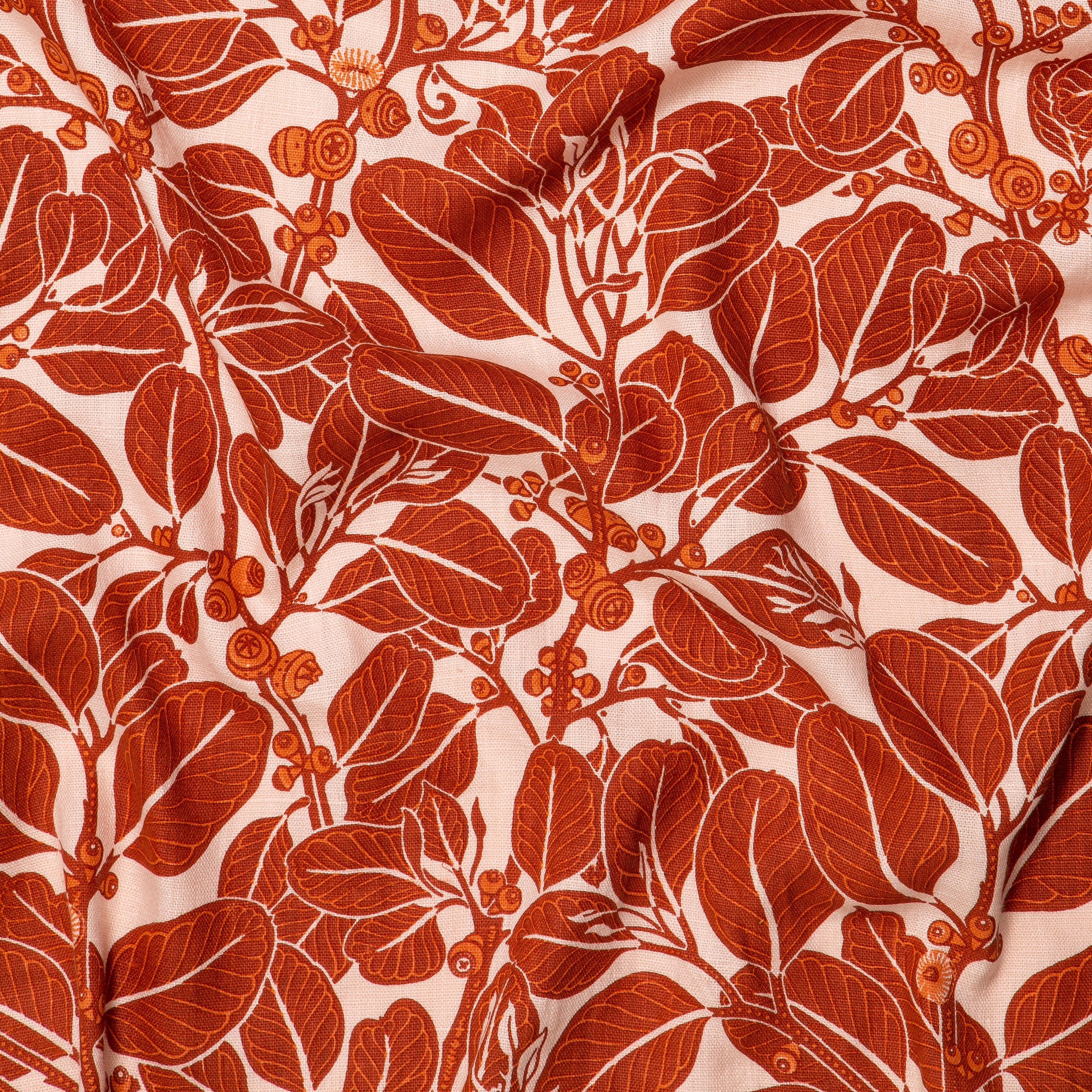 Draped fabric in a dense leaf and stem print in red and orange on a cream field.