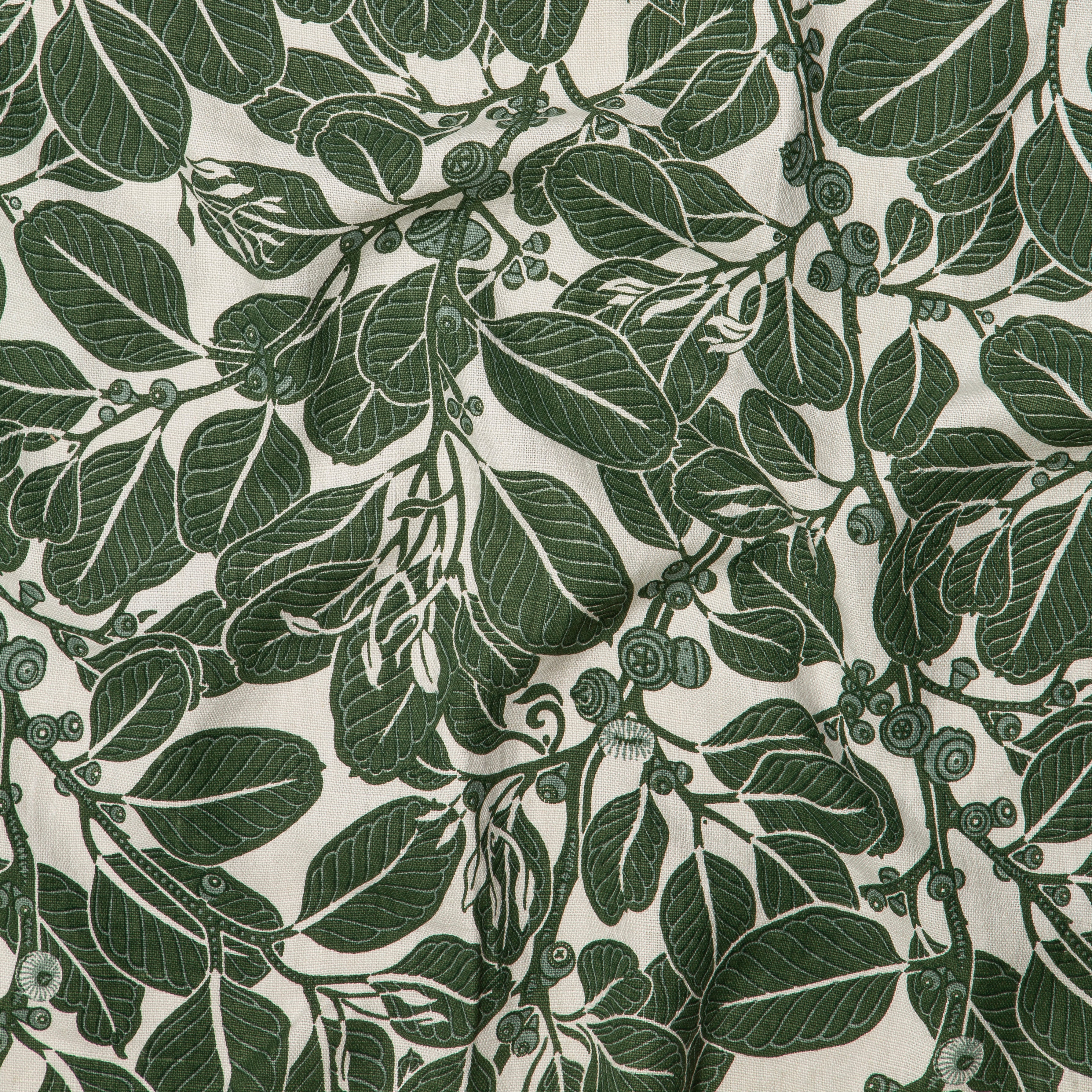 Draped fabric in a dense leaf and stem print in shades of green on a cream field.