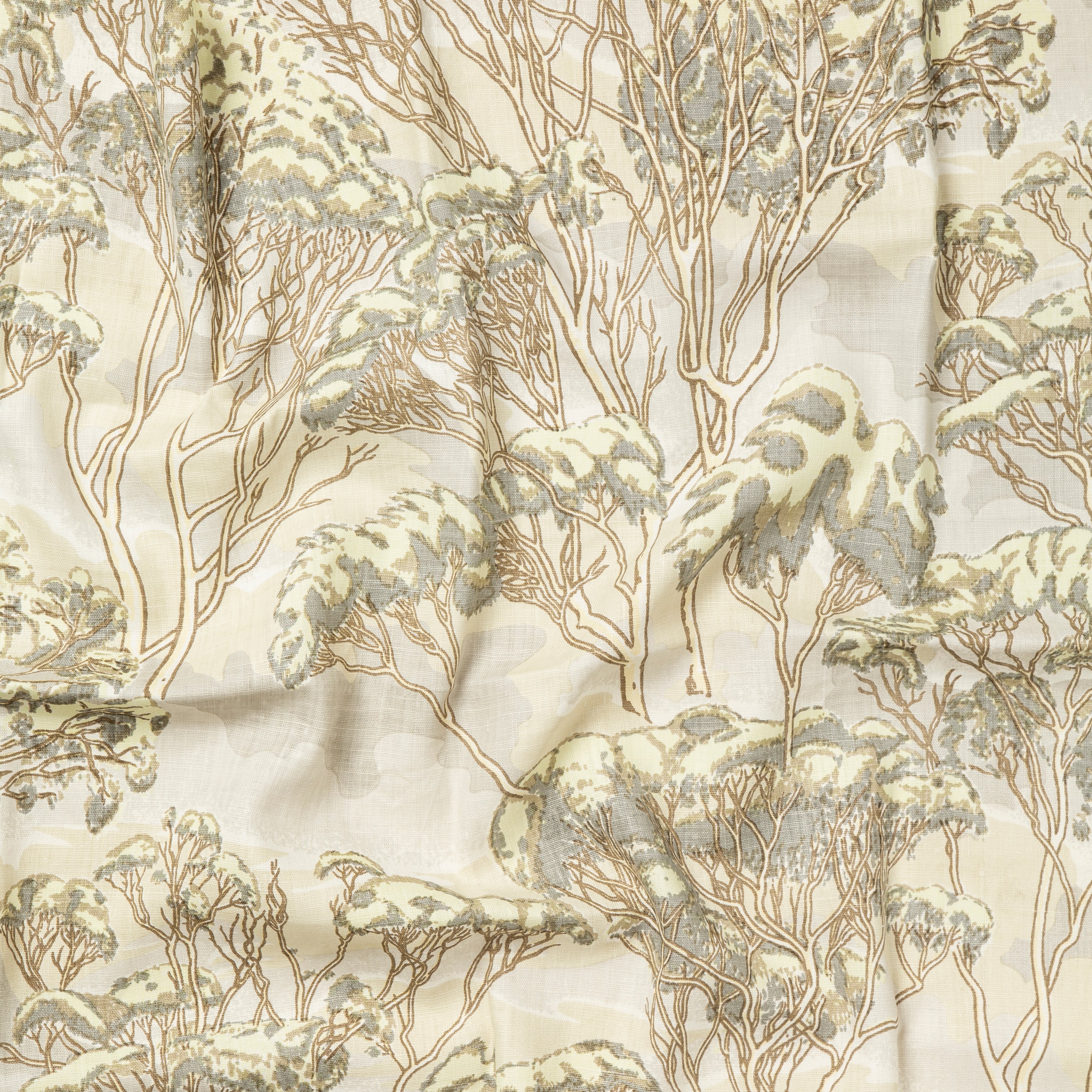 Draped fabric in a painterly tree print in shades of gray and brown on a cream field.