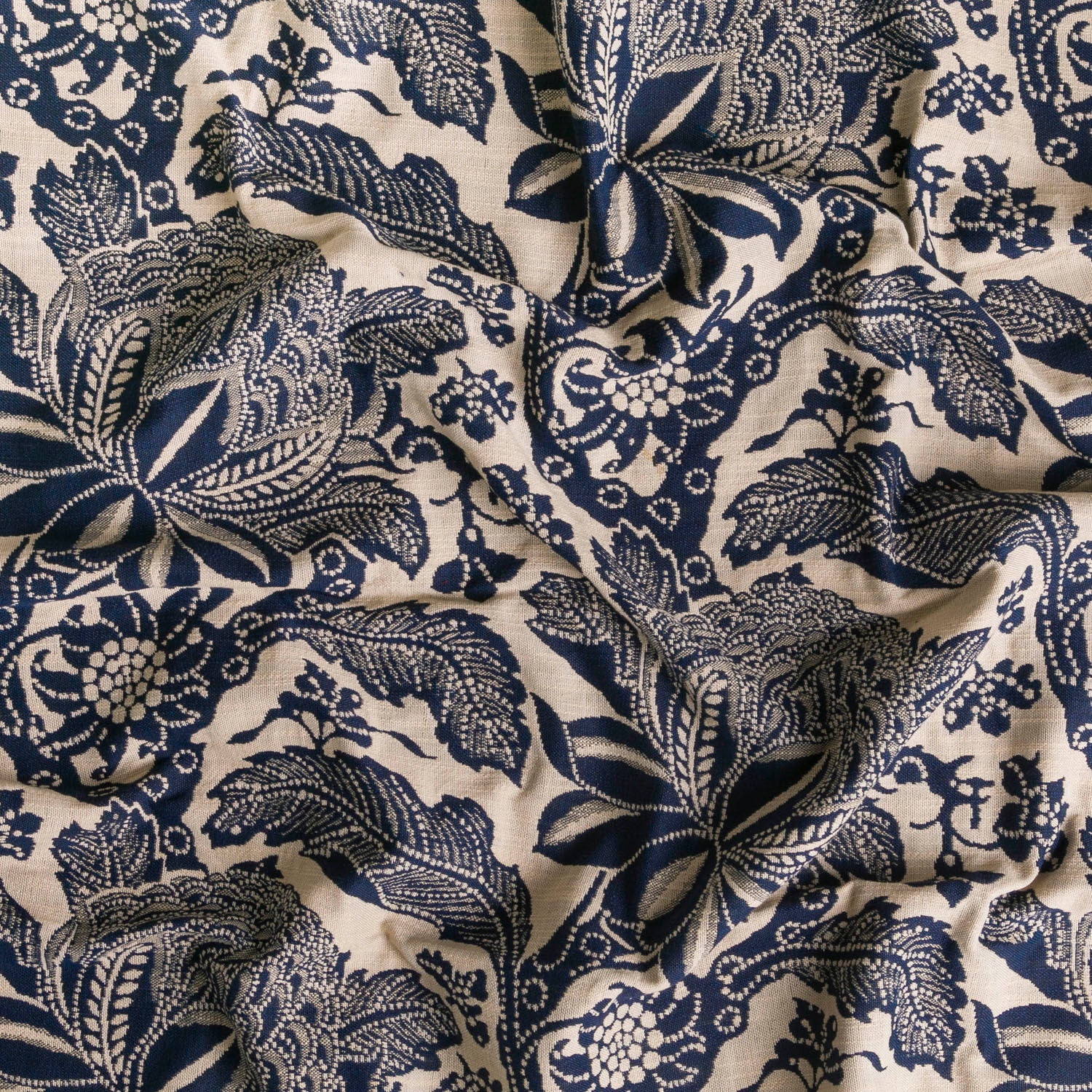 Detail of wallpaper in a repeating botanical print in navy on a cream field.