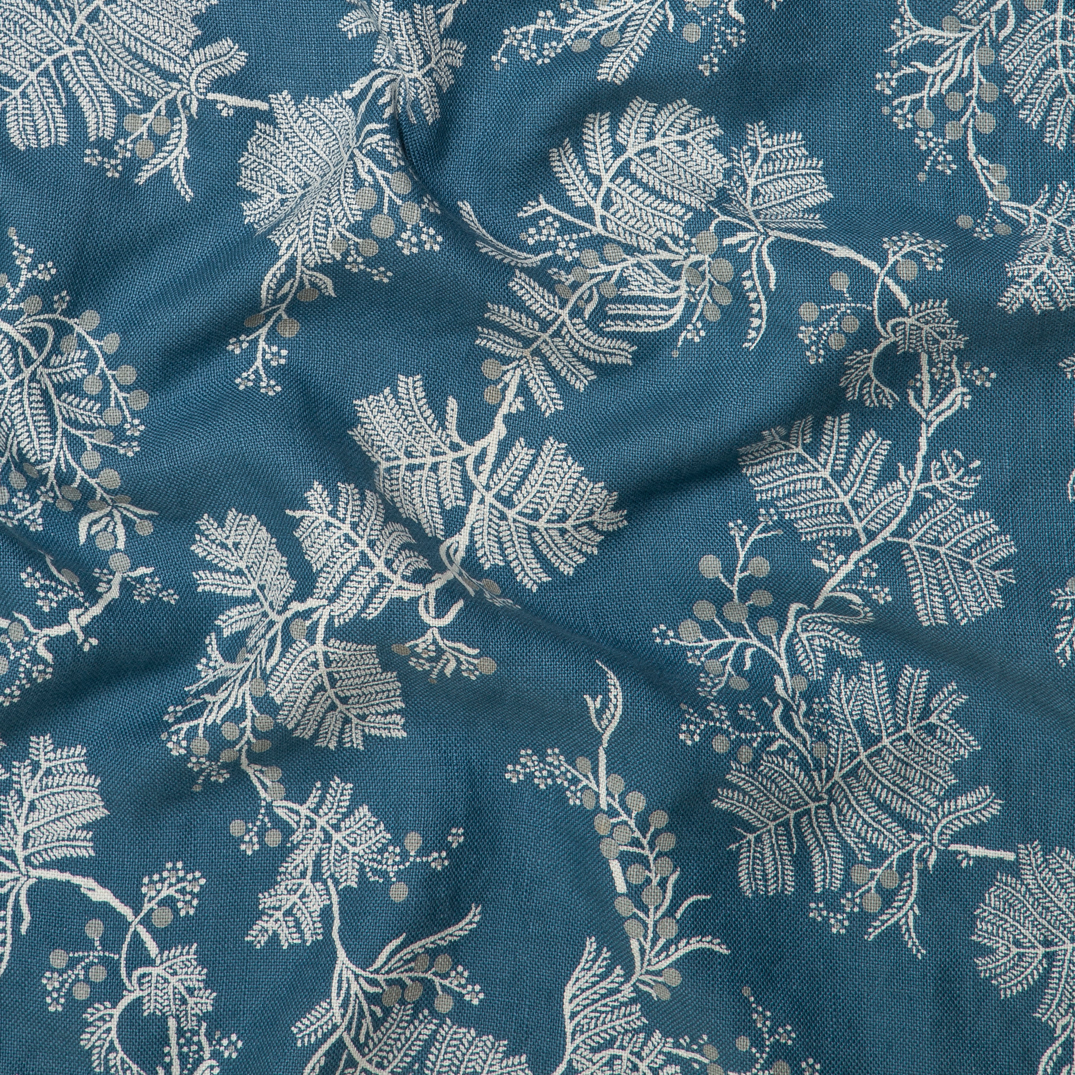 Draped fabric in a leaf and bud print in white and gray on a navy field.