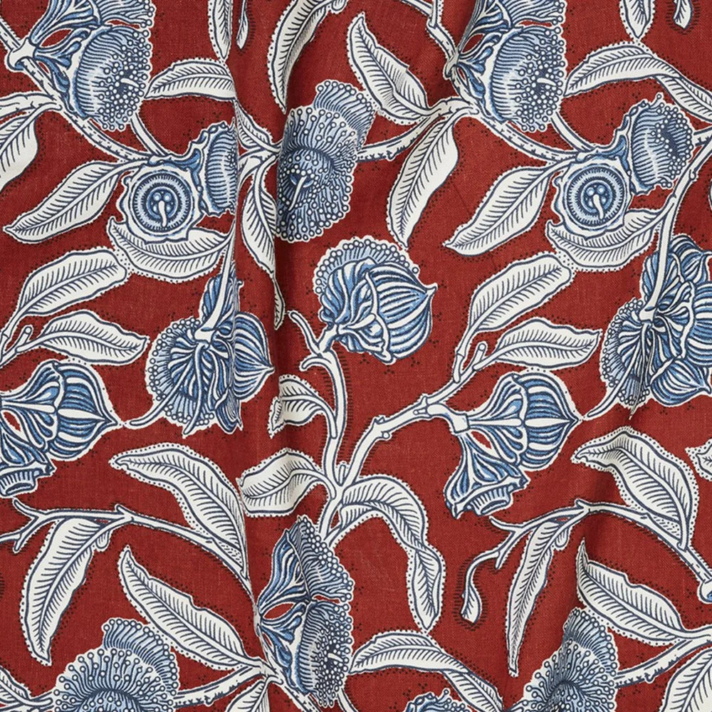 Draped fabric in a painterly floral print in blue, white and on a red field.