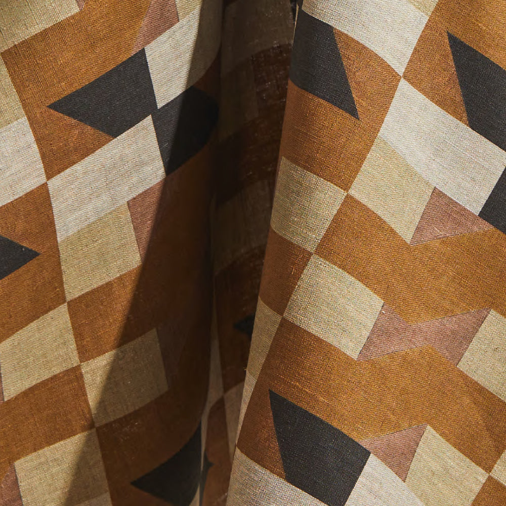 Draped fabric yardage in a large-scale geometric grid in shades of brown, tan and gray.