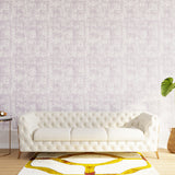 Styled living room tableau with a wall papered in an organic textural print in light purple on a white field.