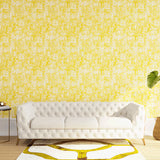 Styled living room tableau with a wall papered in an organic textural print in yellow on a white field.