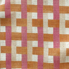 Woven fabric swatch of a geometric pattern of interlocking stripes in muted pink, orange and cream.