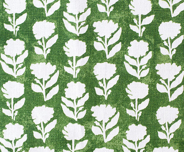 Detail of fabric in a classic floral silhouette print in cream on a dark green field