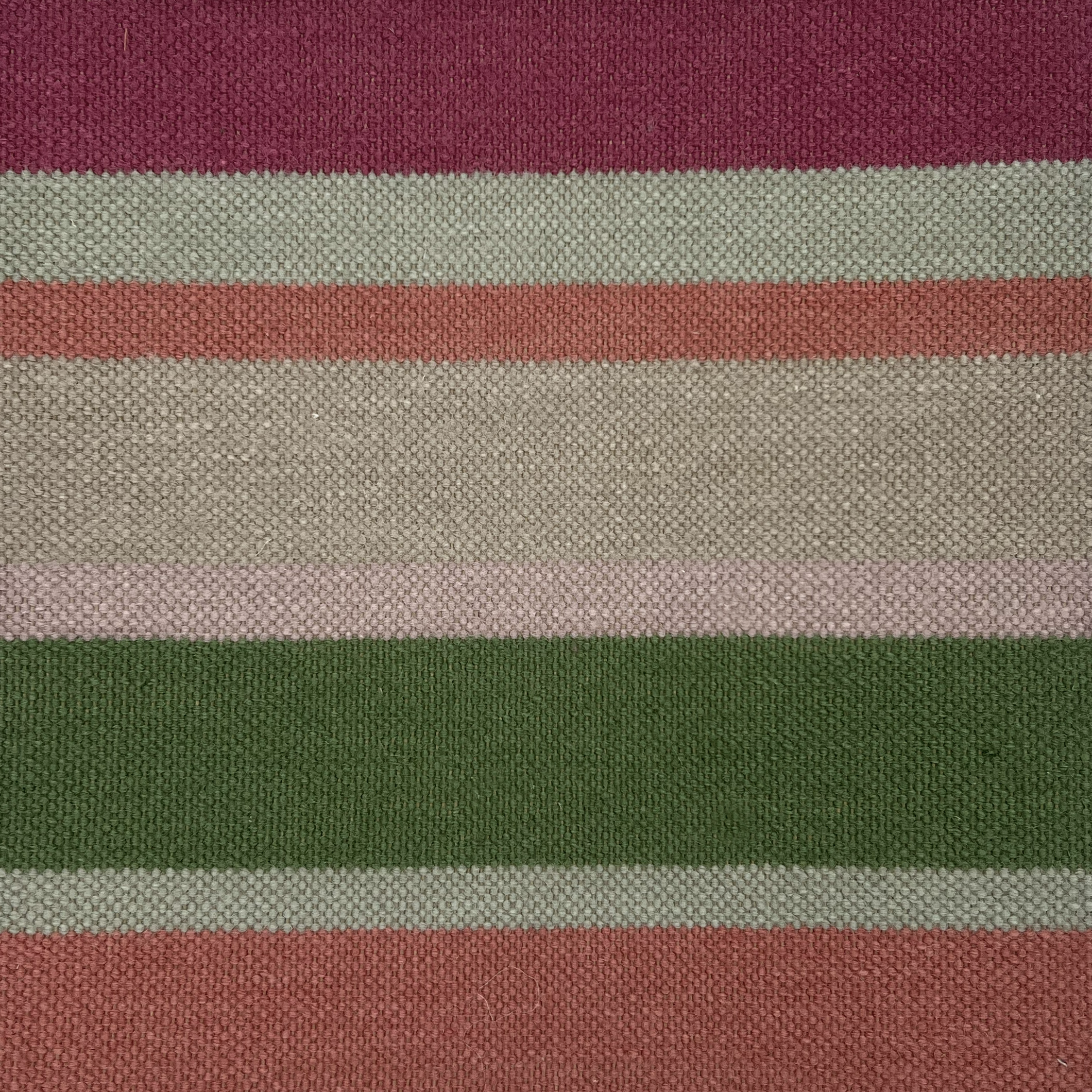 Detail of a Flatweave rug in a mixed width stripe in fuchsia, coral, green, taupe and aqua.