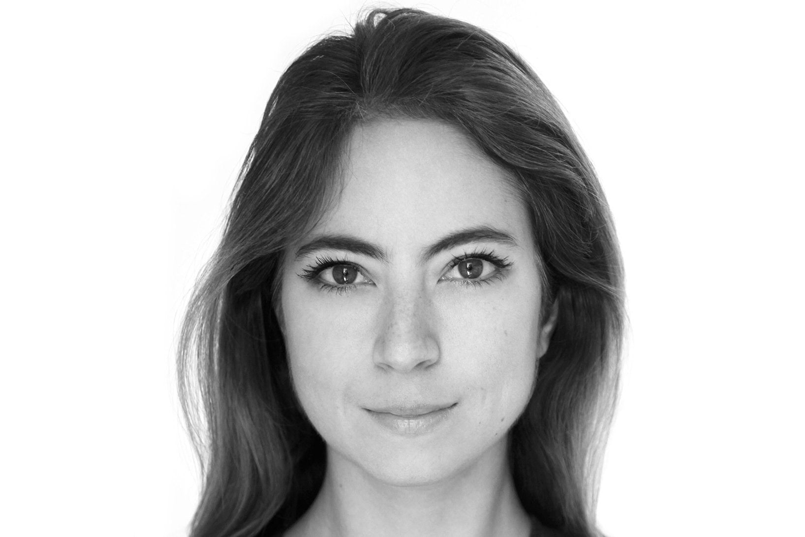 Black-and-white close-up of a brunette woman's face. She is smiling slightly.