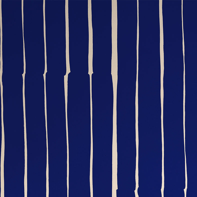 Detail of wallpaper in a playful irregular stripe print in cream on a navy field.