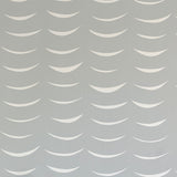 Detail of wallpaper in an abstract crescent print in cream on a gray field.