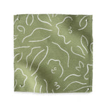 Square fabric swatch in a minimalist floral print in cream on a grass green field.