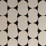 Detail of wallpaper in an abstract curvilinear pattern in gray on a black field.