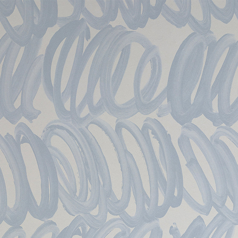 Detail of wallpaper in a playful paint print in blue on a light blue field.