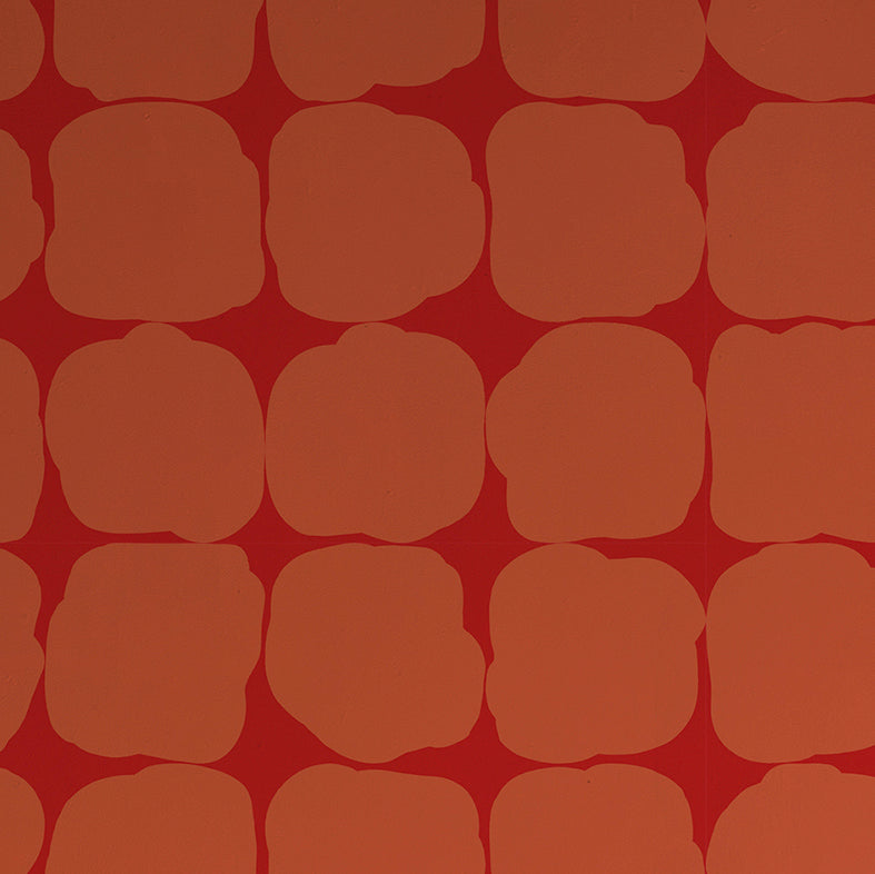 Detail of wallpaper in a repeating blot print in orange on a red field.