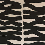 Detail of wallpaper in an abstract zigzag pattern in black on a cream field.