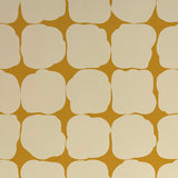 Detail of wallpaper in a repeating blot print in cream on a yellow field.