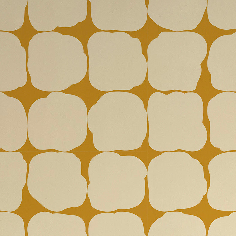 Detail of wallpaper in a repeating blot print in cream on a yellow field.