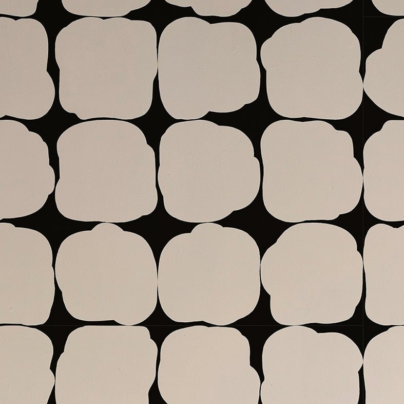 Detail of wallpaper in a repeating blot print in white on a black field.